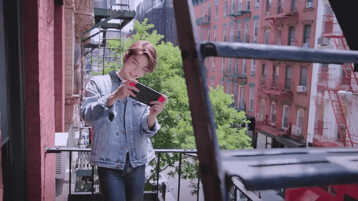 a woman standing on a balcony looking at her cell phone