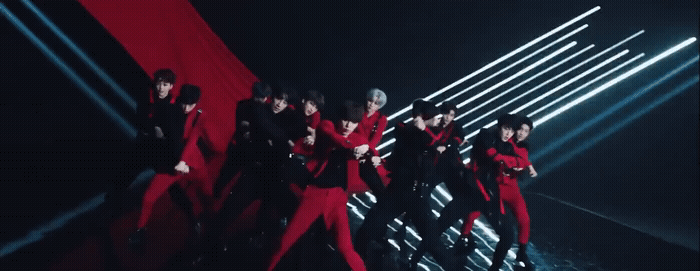 a group of men in red outfits standing on a stage