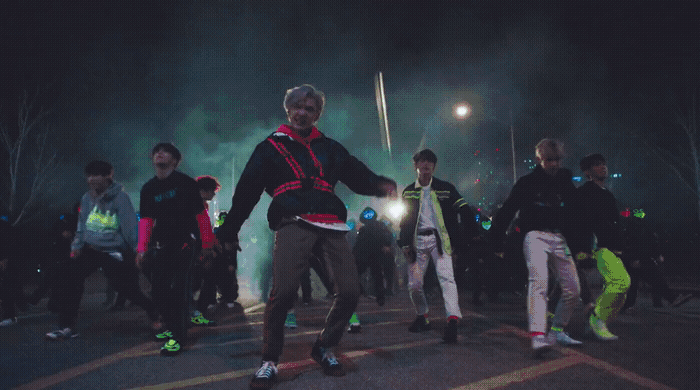 a group of young men standing on top of a parking lot