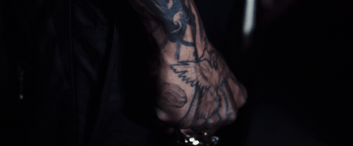 a man with a tattoo on his arm holding a cell phone