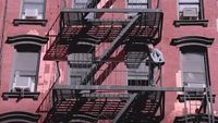 a man standing on a fire escape in front of a building