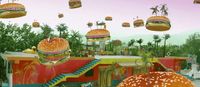 a large hamburger with many hamburgers flying above it