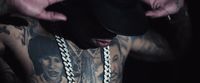 a man with a hat and a chain around his neck