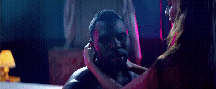 a man holding a woman's neck in a dimly lit room