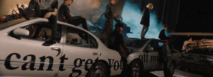 a group of people standing on top of a car