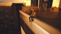 a man sitting on top of a tall building
