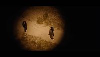 a couple of people walking down a dirt road