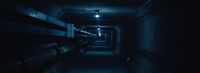 a long dark hallway with benches and lights
