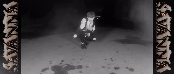 a black and white photo of a person sitting in the snow