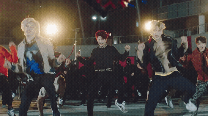 a group of young men dancing in front of a crowd