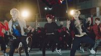 a group of young men dancing in front of a crowd