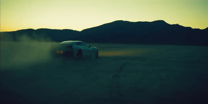 a car driving on a dirt road in the middle of the desert