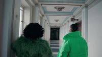 a man and a woman walking down a hallway