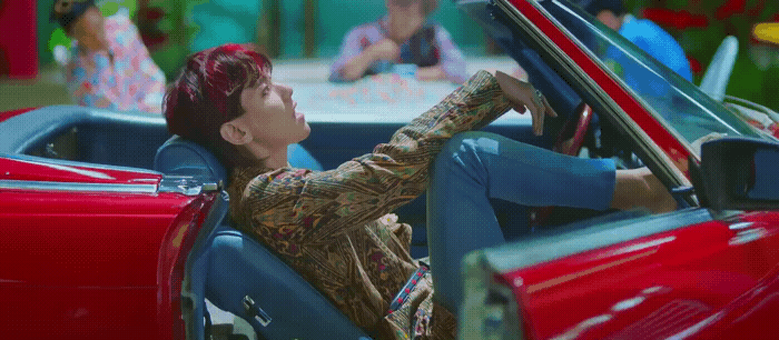 a woman sitting in a red convertible car