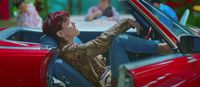 a woman sitting in a red convertible car