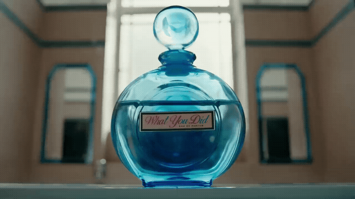 a blue bottle of perfume sitting on top of a table