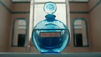 a blue bottle of perfume sitting on top of a table