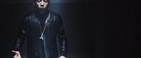 a man in a black leather outfit holding a knife