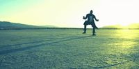 a man running across a dry grass covered field
