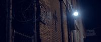 a street light on a brick building at night