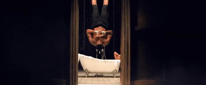 a man hanging upside down in a bathtub