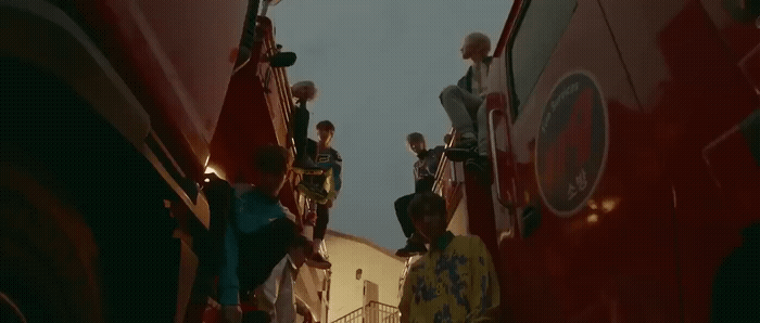 a group of people standing on the side of a bus