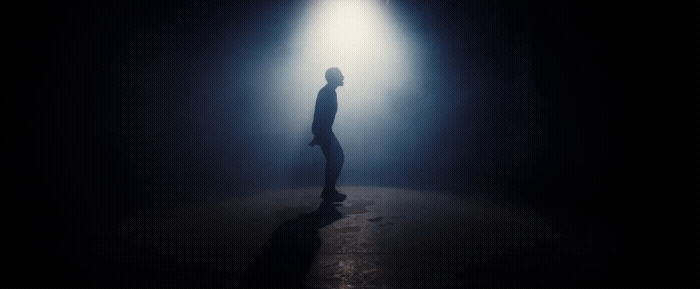 a person standing in a dark room with a light on