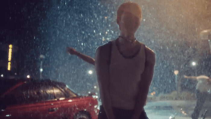 a mannequin standing in the rain at night