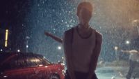 a mannequin standing in the rain at night