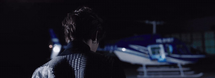 a man standing in front of a plane at night