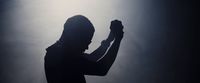 a silhouette of a man holding a cell phone