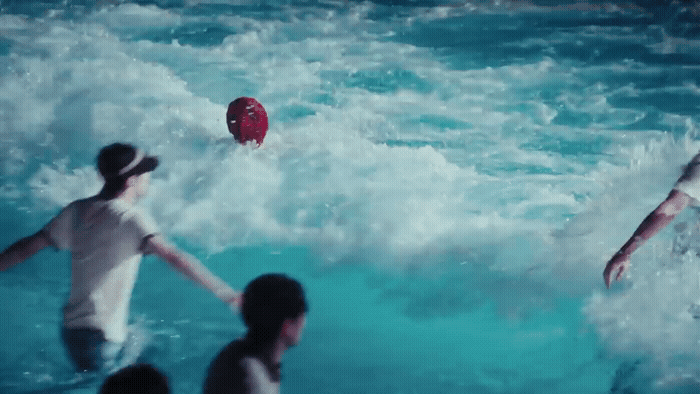 a group of people in the water playing with a frisbee