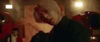 a man with white hair standing in front of a fire truck