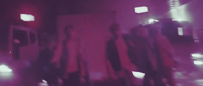 a blurry photo of a group of people walking down a street