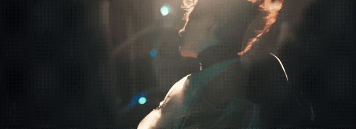 a person standing in a dark room with a light shining on them