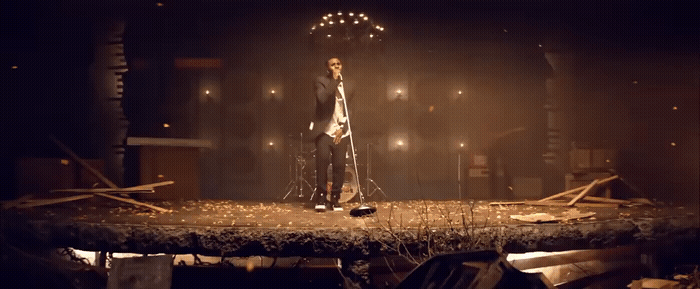 a man standing on top of a stage in a dark room