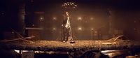 a man standing on top of a stage in a dark room