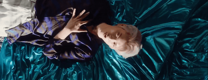 a baby is laying on a shiny blue sheet