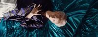 a baby is laying on a shiny blue sheet