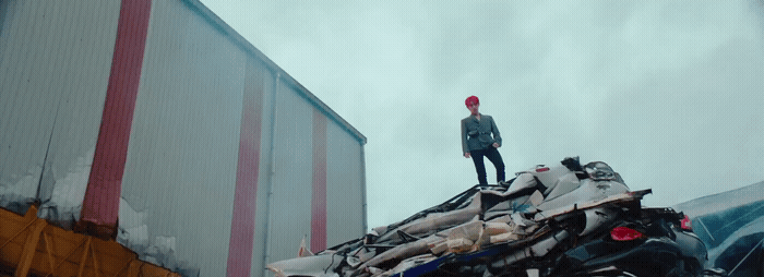 a man standing on top of a pile of junk