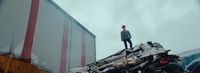 a man standing on top of a pile of junk