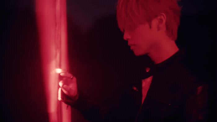 a man in a black shirt holding a red light
