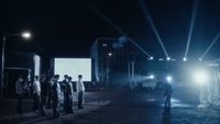 a group of people standing on a street at night
