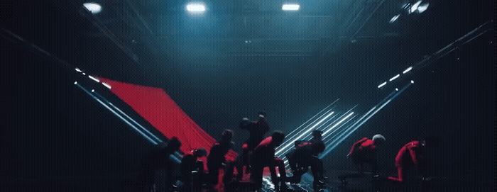 a group of people standing around in a dark room