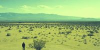a man standing in the middle of a desert