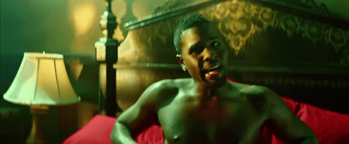 a shirtless man sitting on top of a red couch