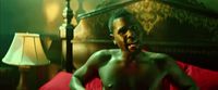 a shirtless man sitting on top of a red couch