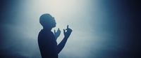 a silhouette of a person holding a finger up