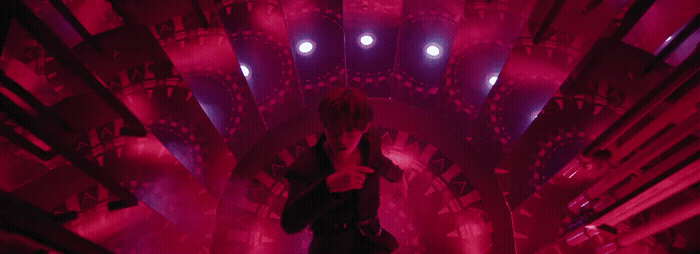 a woman standing in a room with red lights