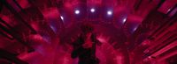 a woman standing in a room with red lights